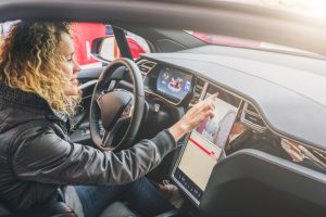 woman using her car's very large built-in infotainment system